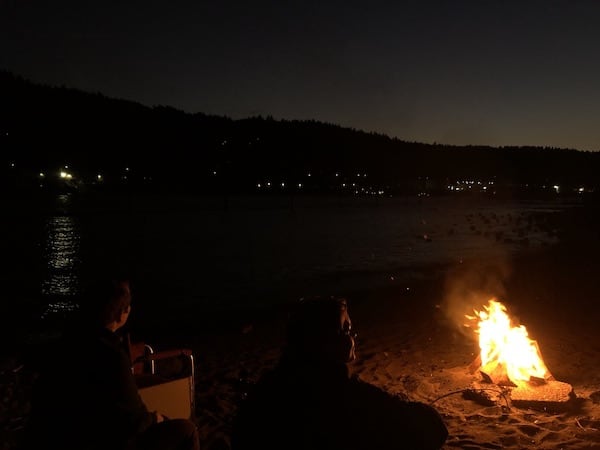 Friends around a campfire by the river